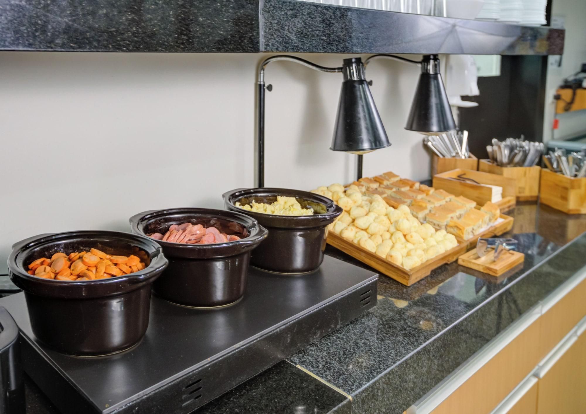 A buffet setup with various food items in black containers on a countertop.