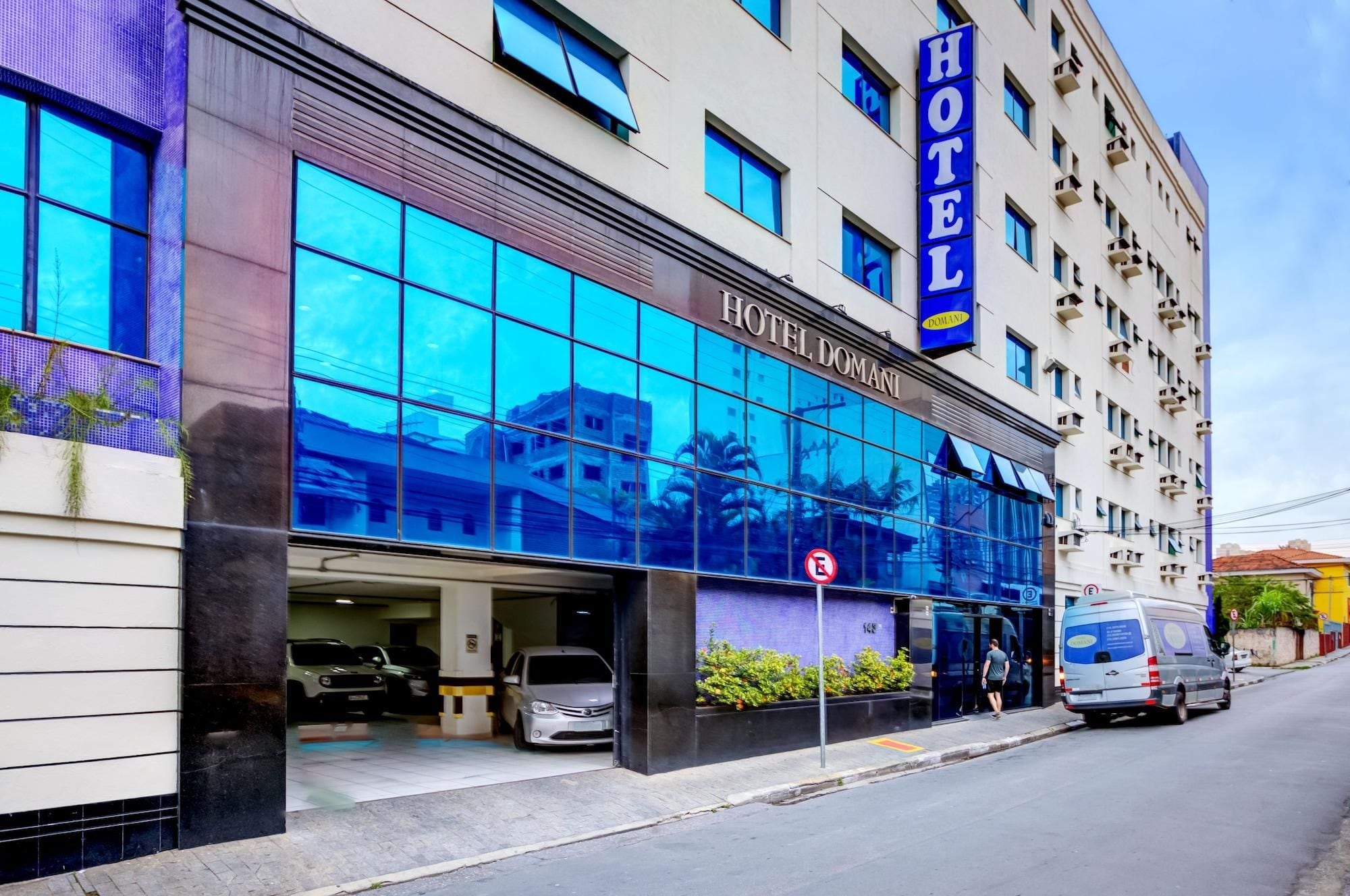 Un hotel amb façana moderna, grans finestres i entrada ben visible.