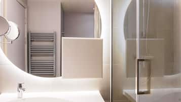 A modern bathroom with a freestanding sink, a glass-enclosed shower, and a towel rack.