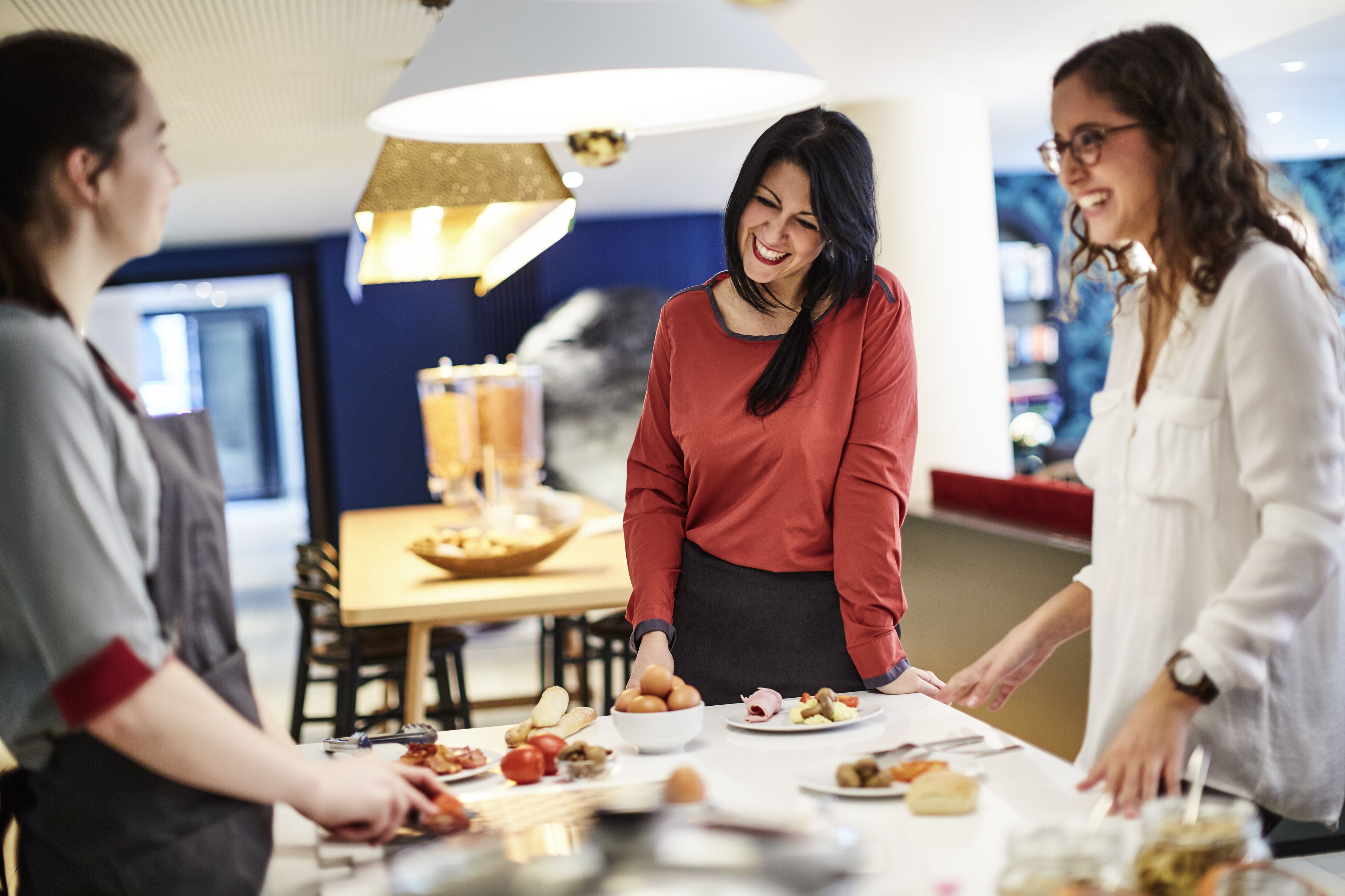 A group of people at a dining table with various food items and a modern interior design.