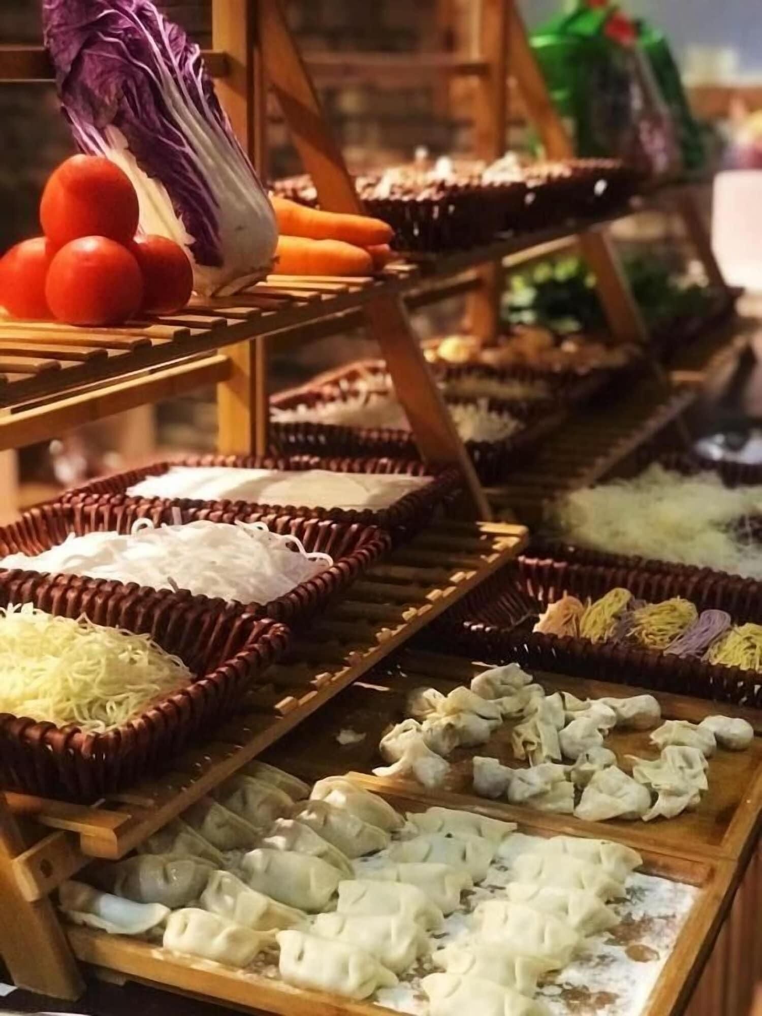 A variety of food items displayed on wooden racks, including noodles, dumplings, and vegetables.