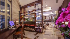 A hotel lobby with a reception desk, a fireplace, and a large bookshelf. - Narada Boutique Hotel (Wuhan)
