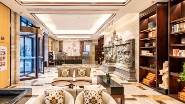 A spacious lobby with a reception desk, seating area, and a decorative fountain. - Narada Boutique Hotel (Wuhan)