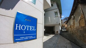 A hotel sign with a blue background and white lettering, indicating the hotel's name and location in Bosnia and Herzegovina.