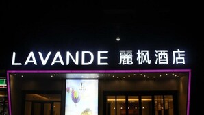 La fachada del hotel Lavande con su nombre iluminado en letras blancas.