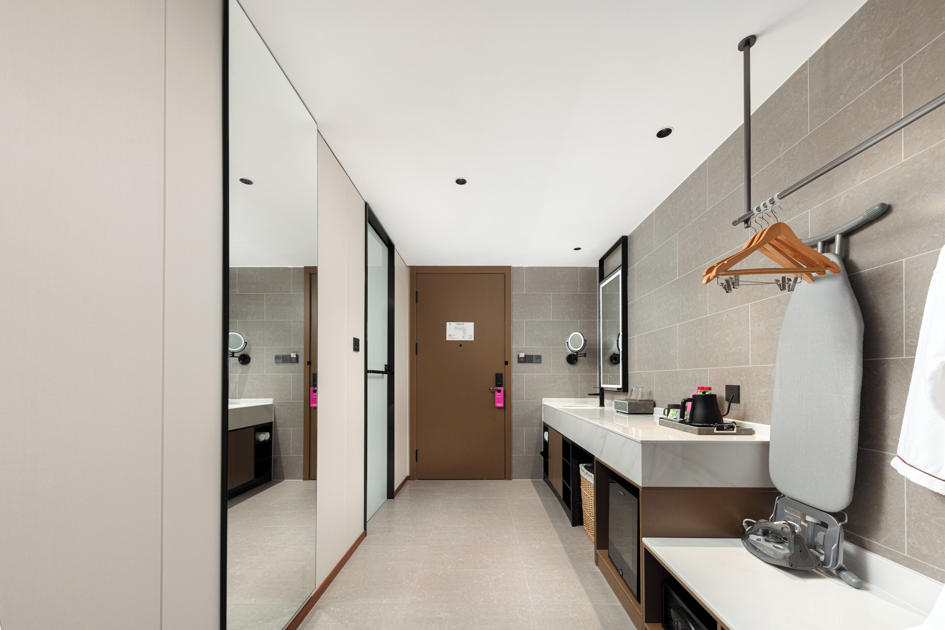 Een moderne badkamer met een grote spiegel, een handdoekhouder en een douchehoek.
