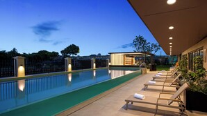 A swimming pool with lounge chairs and a covered area. - Wyndham Garden Shanghai Pudong (Shanghai)