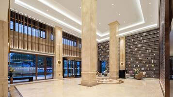A spacious lobby with high ceilings, large columns, and a central seating area.