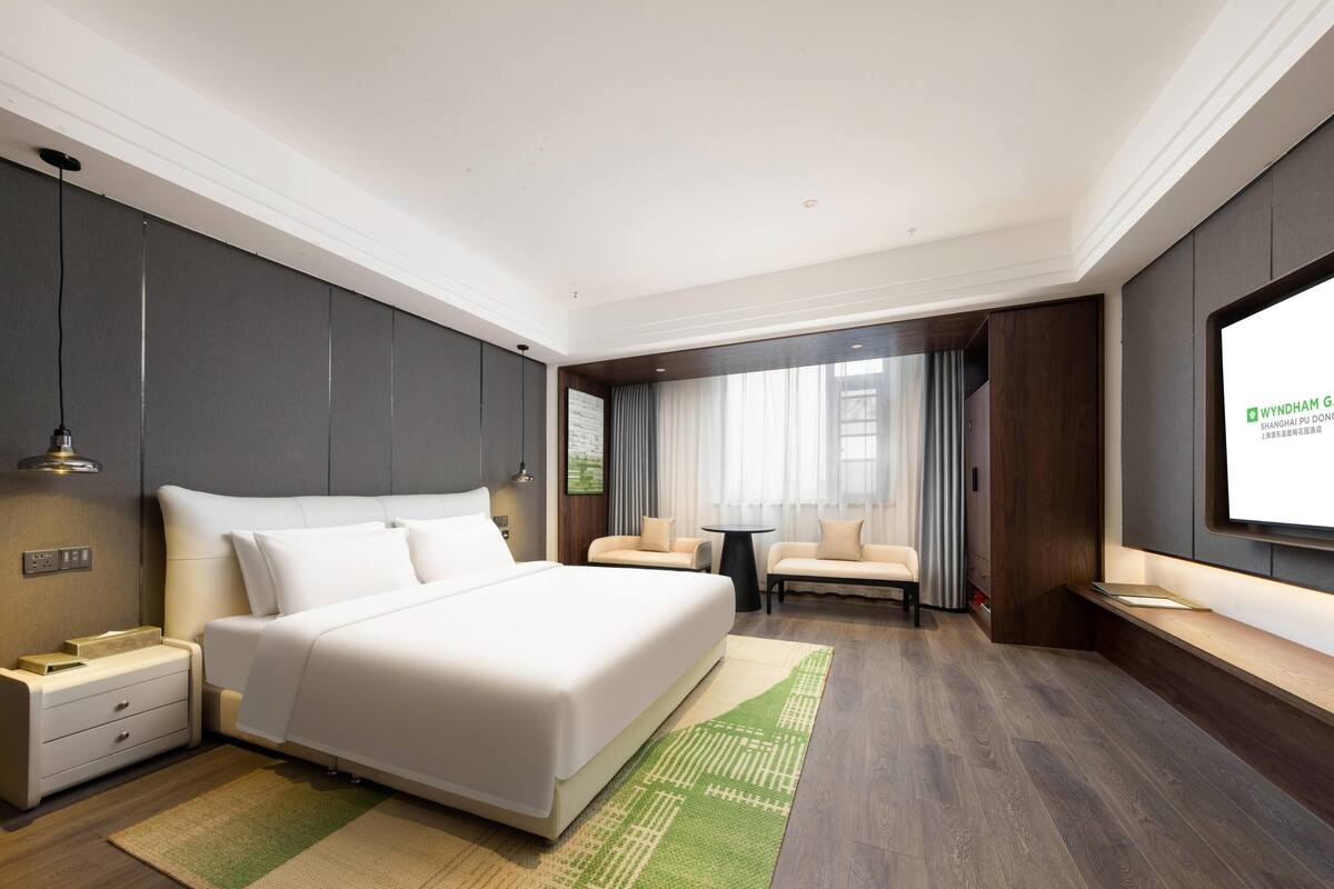 Une chambre d’hôtel moderne équipée d’un grand lit, d’un bureau, d’un canapé et d’une télévision.