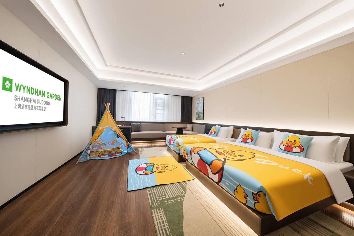 Une chambre d’hôtel avec un grand lit, une télévision, un canapé et une décoration qui rappelle une tente.