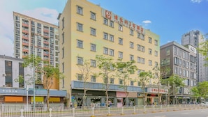 A multi-story hotel with a yellow facade, multiple windows, and a sign indicating it is a hotel. - Vienna 3 Best Hotel Xili Nan Ke Da (Shenzhen)