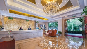 A hotel lobby with a reception desk, a chandelier, and a red carpet leading to the entrance. - Vienna 3 Best Hotel Xili Nan Ke Da (Shenzhen)