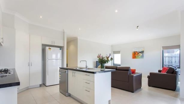 A modern kitchen with white cabinets, a built-in island, and a gas stove. - Bradford Place (GLADSTONE PARK)