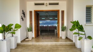 A spacious entrance with a view of a dining area and mountains in the background. - Villa Salamandra (Las Galeras)