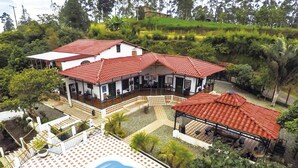 Uma casa grande com vários telhados vermelhos e um amplo pátio.