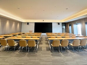 A conference room with rows of tables and chairs, a projector screen, and a large window. - JI Hotel Guangzhou Tianhe East Railway Station (Guangzhou)