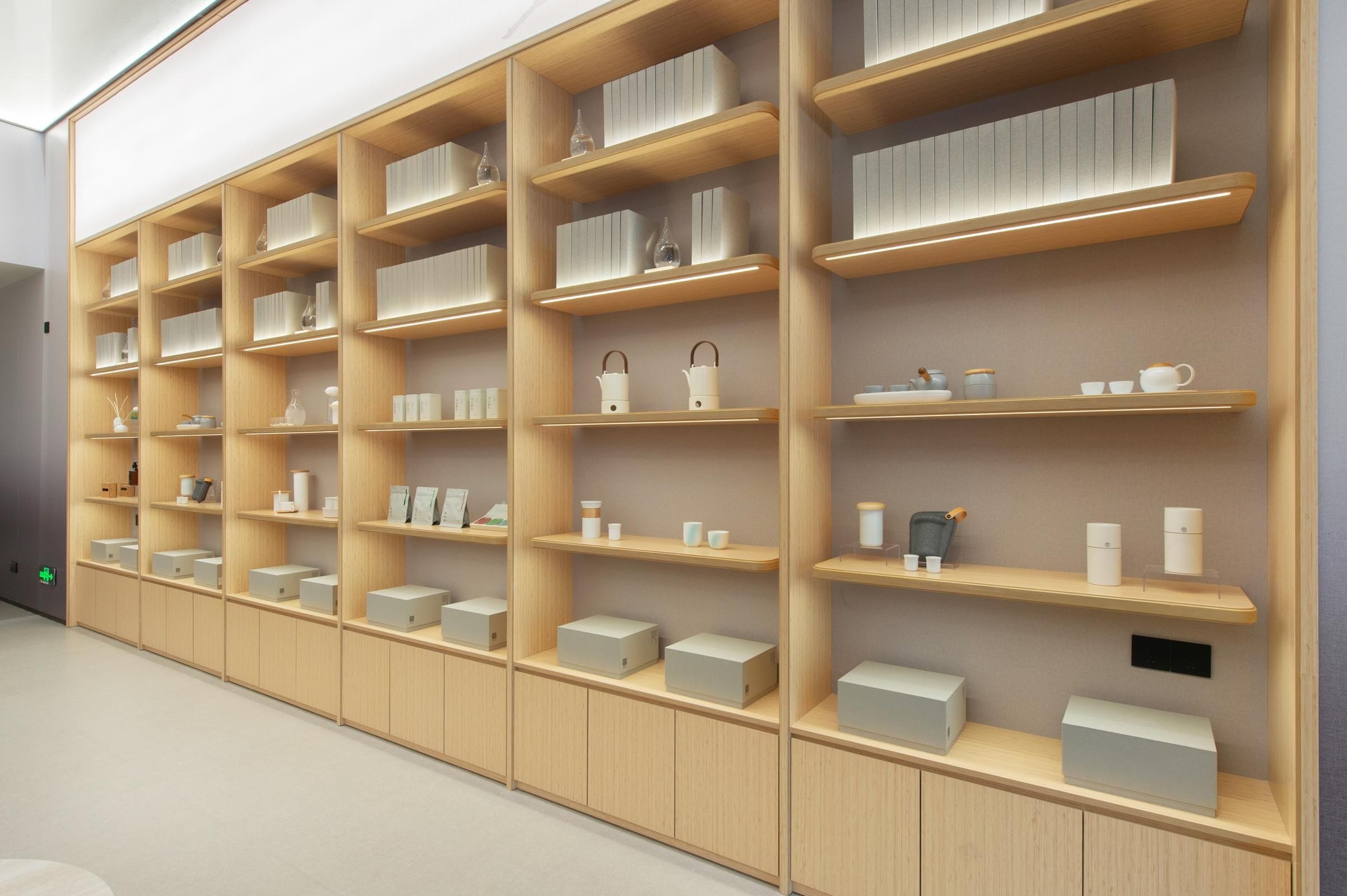 A modern interior with multiple wooden shelves displaying various items.