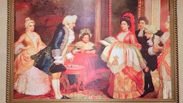 A framed painting with a group of people in historical attire.