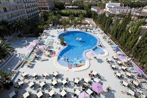 A large pool with a unique shape surrounded by lounge chairs and umbrellas. - Hostal BEI Juan Mallorca (Sant Llorenc des Cardassar)