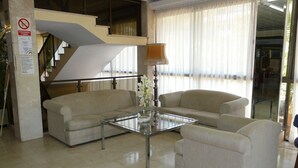 A modern living room with a glass coffee table, two sofas, and a lamp. - Hostal BEI Juan Mallorca (Sant Llorenc des Cardassar)