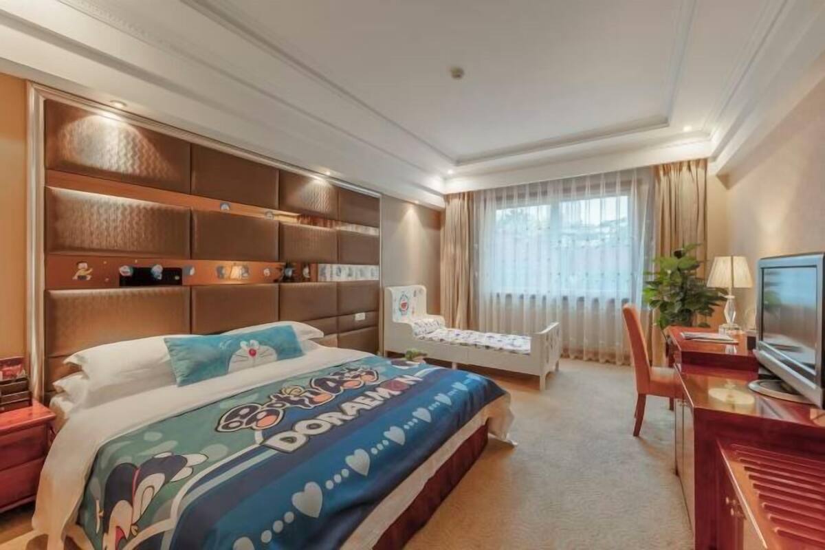 Une chambre d’hôtel avec un lit, un bureau, une chaise, une télévision et un piano.