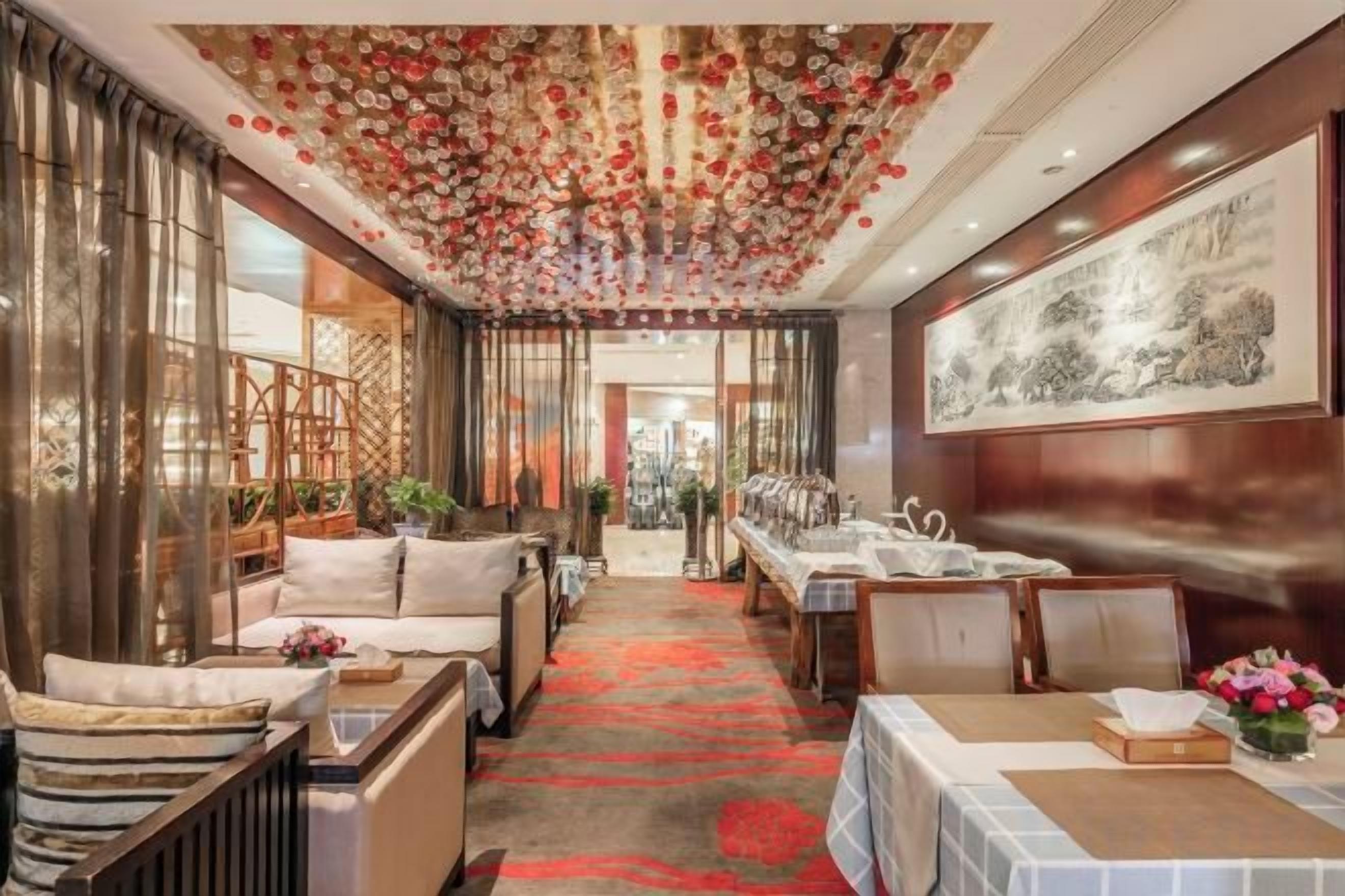 A hotel lobby with a reception desk, seating area, and a decorative ceiling.