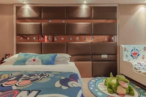 Une chambre d’hôtel avec un grand lit, une tête de lit rembourrée et un jouet en peluche sur le sol.