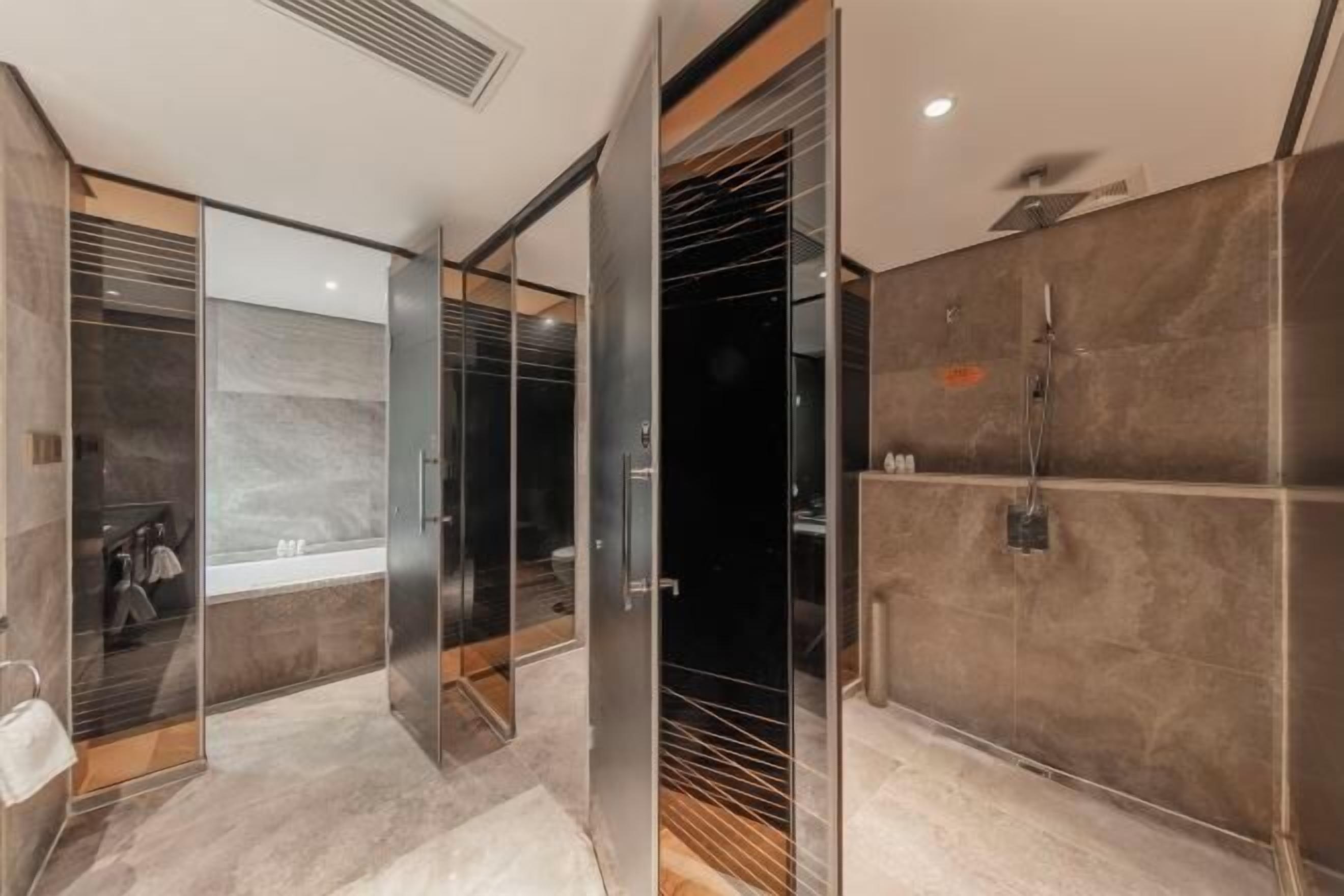 A modern bathroom with a glass-enclosed shower, a bathtub, and a vanity with a mirror.