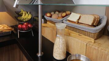 Buffet de café da manhã com pães, doces e frutas.