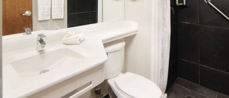 A modern bathroom with a white sink, toilet, and shower area.
