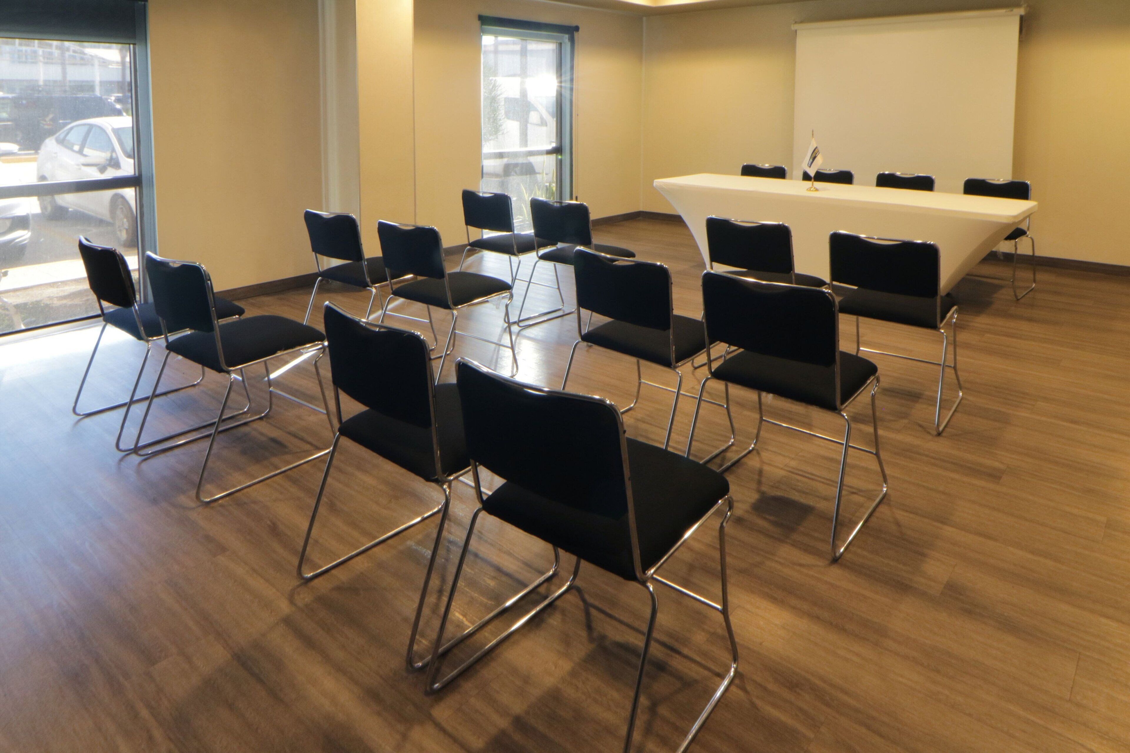 Un salón de conferencias con una larga mesa y numerosas sillas.