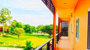 A corridor with a balcony overlooking a green landscape. - Won DD Place (Roi Et)