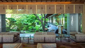 Un intérieur moderne avec des coins salon et une vue sur un jardin luxuriant.