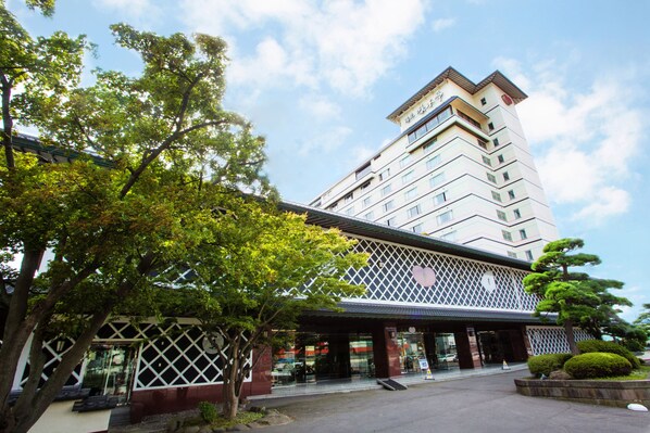 A multi-story hotel with a modern design, featuring a prominent entrance with a covered walkway and a large glass facade. - Yumoto Takubokutei (Hakodate)