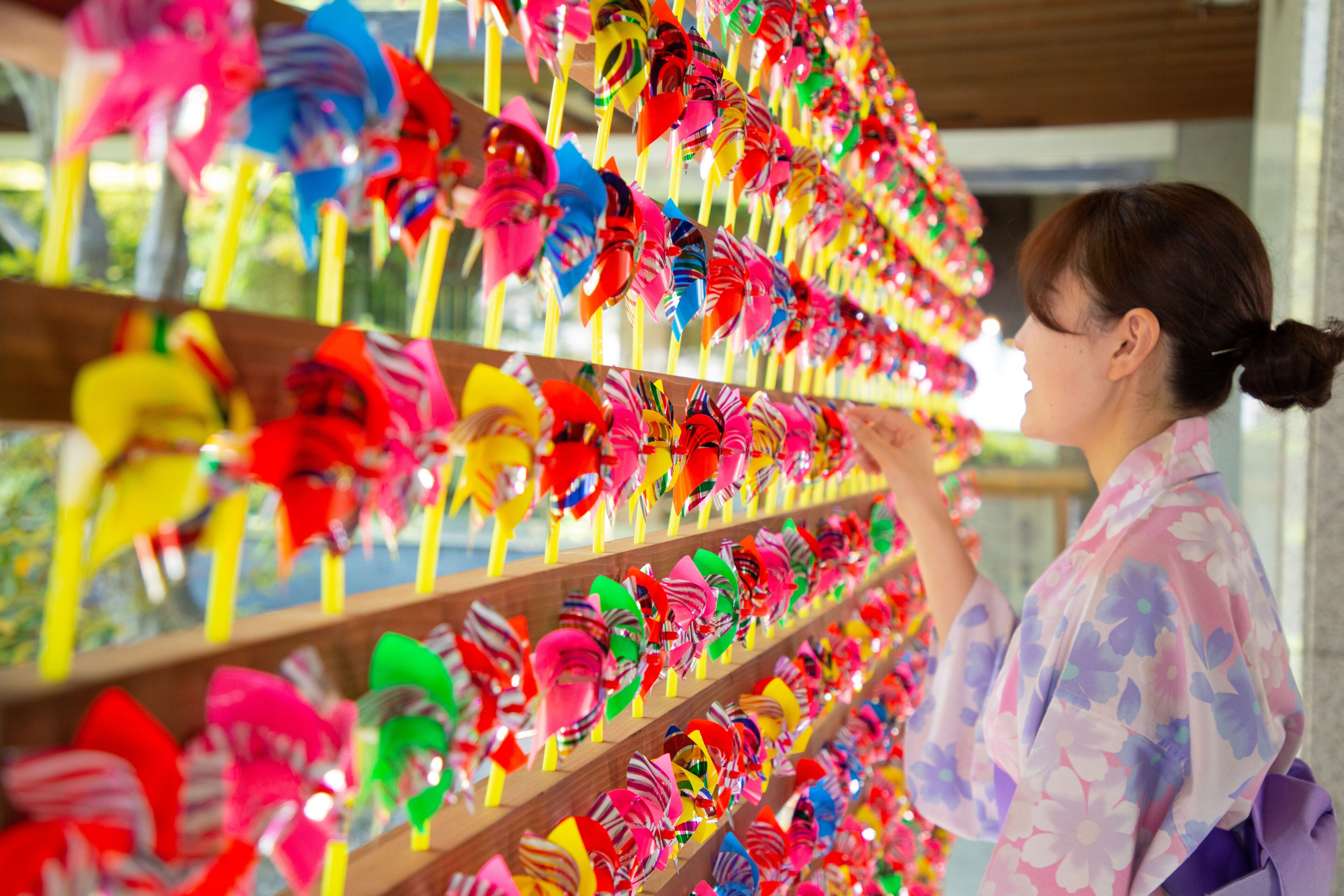 A person browsing colorful pinwheels on shelves.