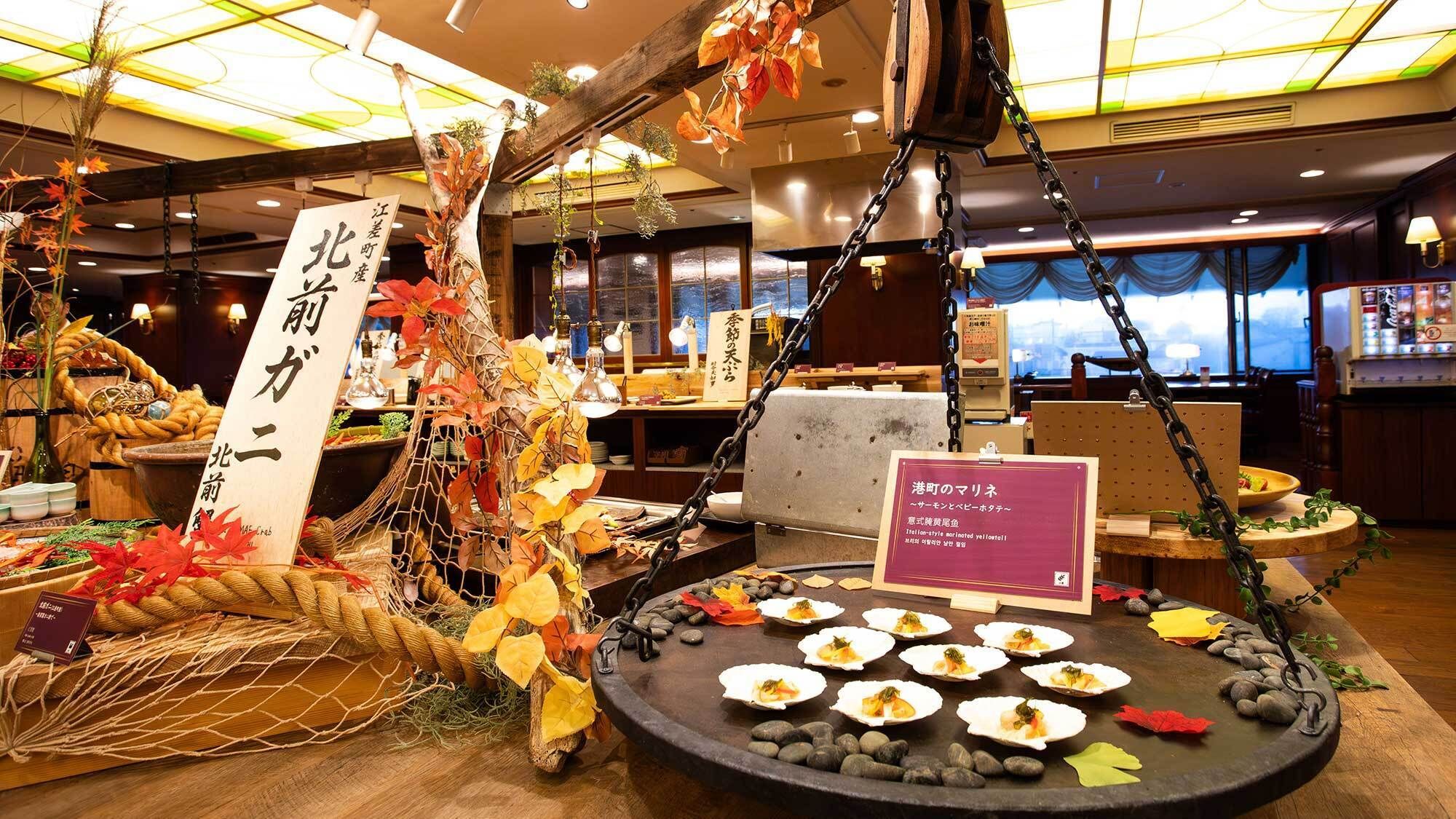 A restaurant interior with a sushi display, autumn decorations, and a sign indicating a seasonal menu.