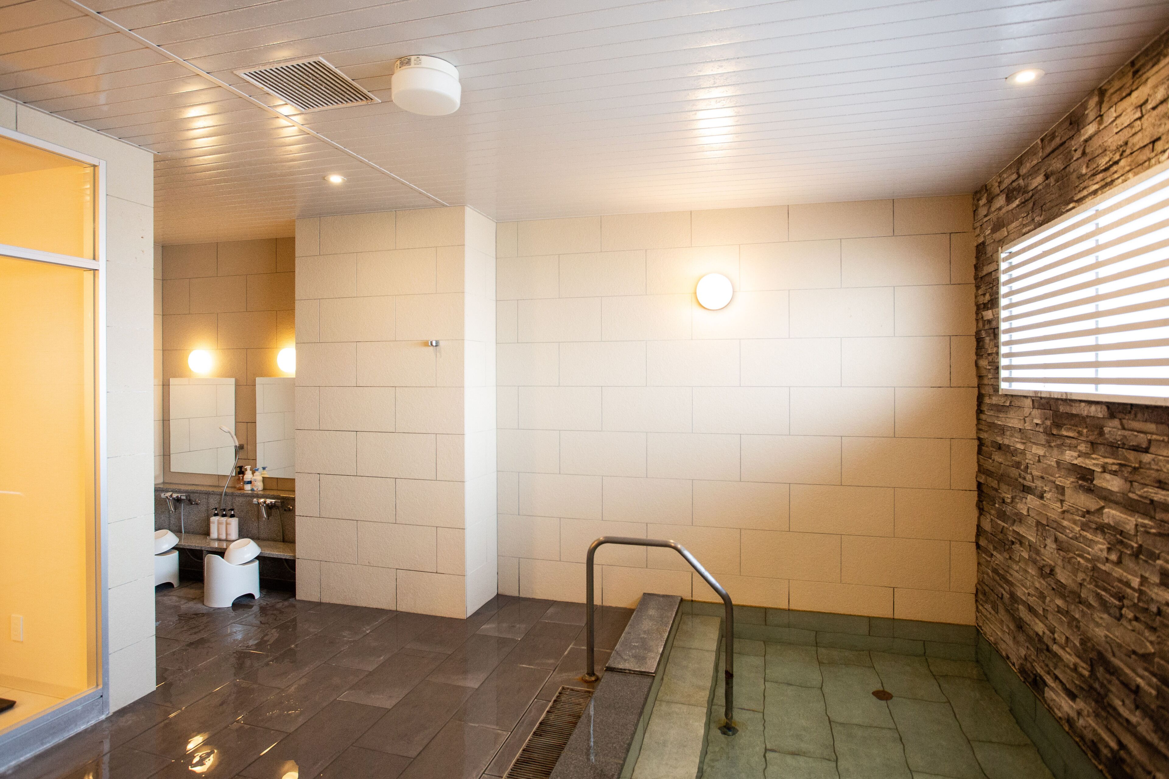 A modern bathroom with a shower, toilet, and sink.