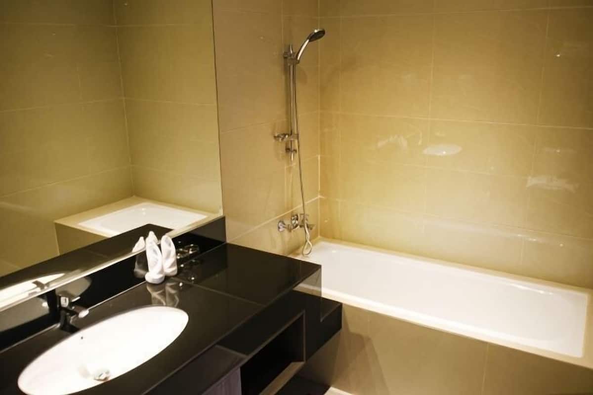 Ein Badezimmer mit Badewanne, Waschbecken und Spiegel.