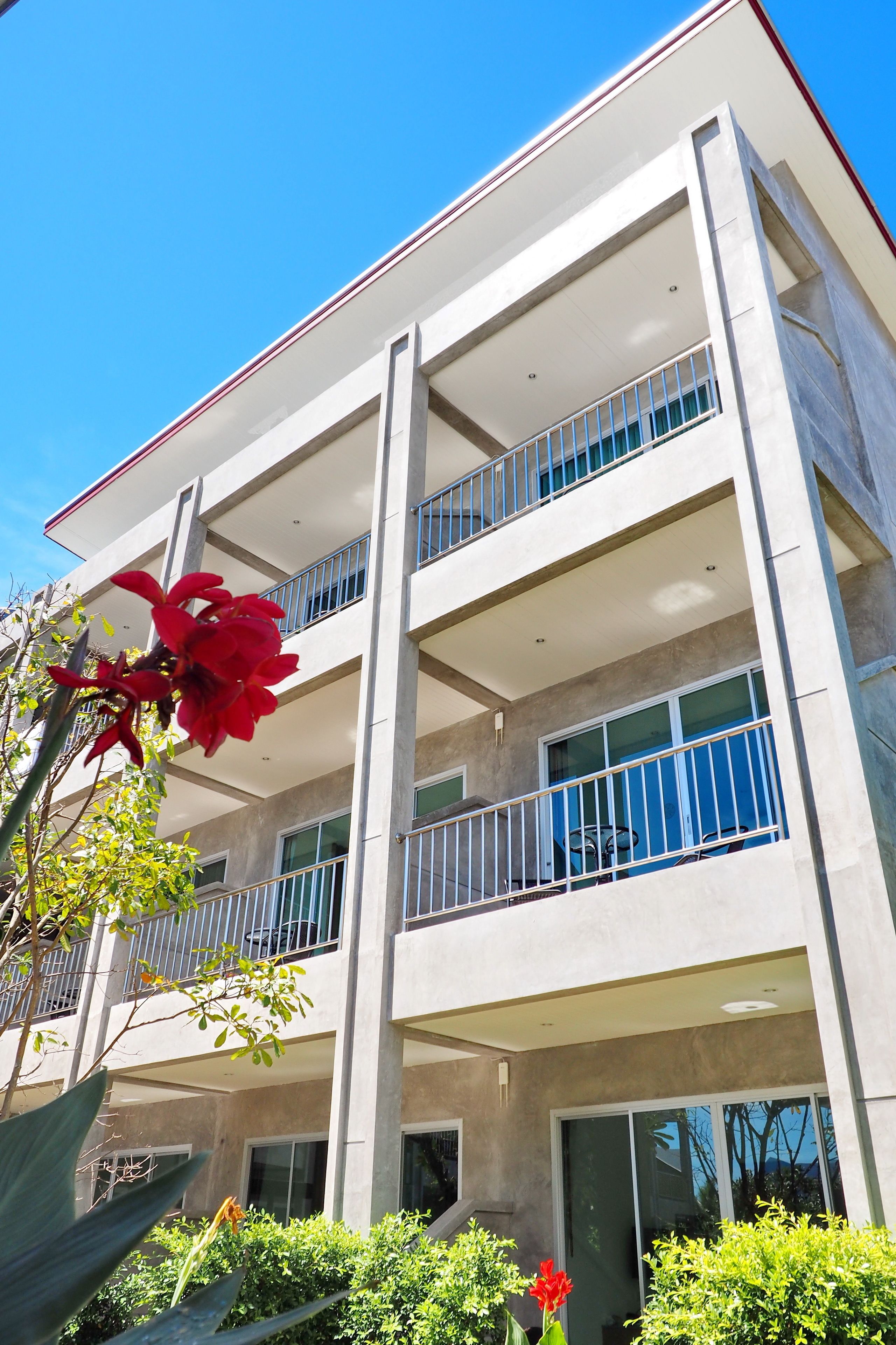 Un edificio de varios pisos con balcones, ventanas amplias y cielo despejado.