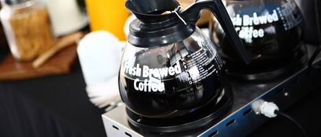 Una cafetera con la etiqueta 'Café Recién Hecho' sobre una encimera.