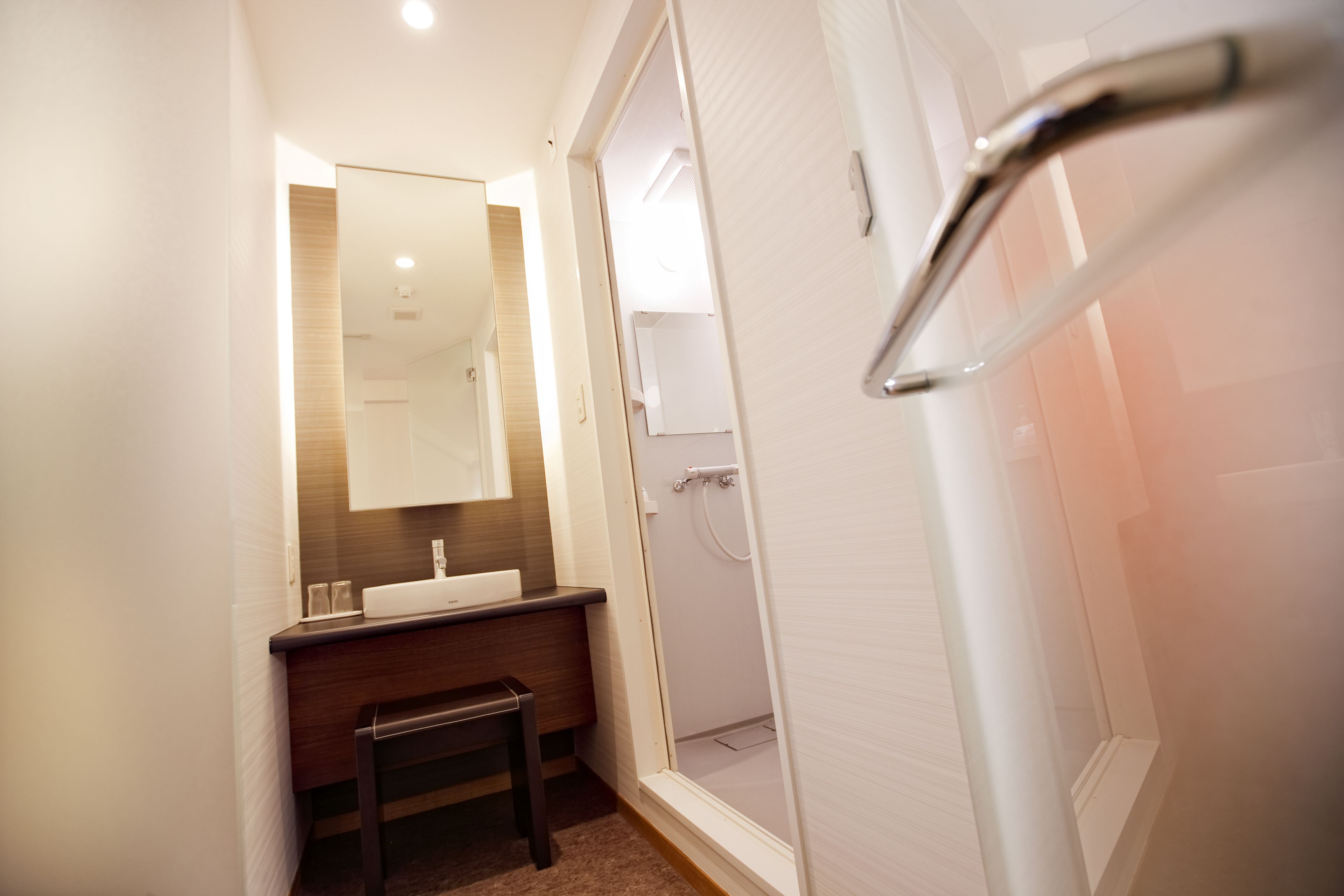 Une salle de bain moderne avec un meuble-lavabo, un miroir et un espace douche.