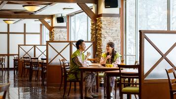 Um restaurante com mobiliário de madeira, paredes de pedra e grandes janelas.