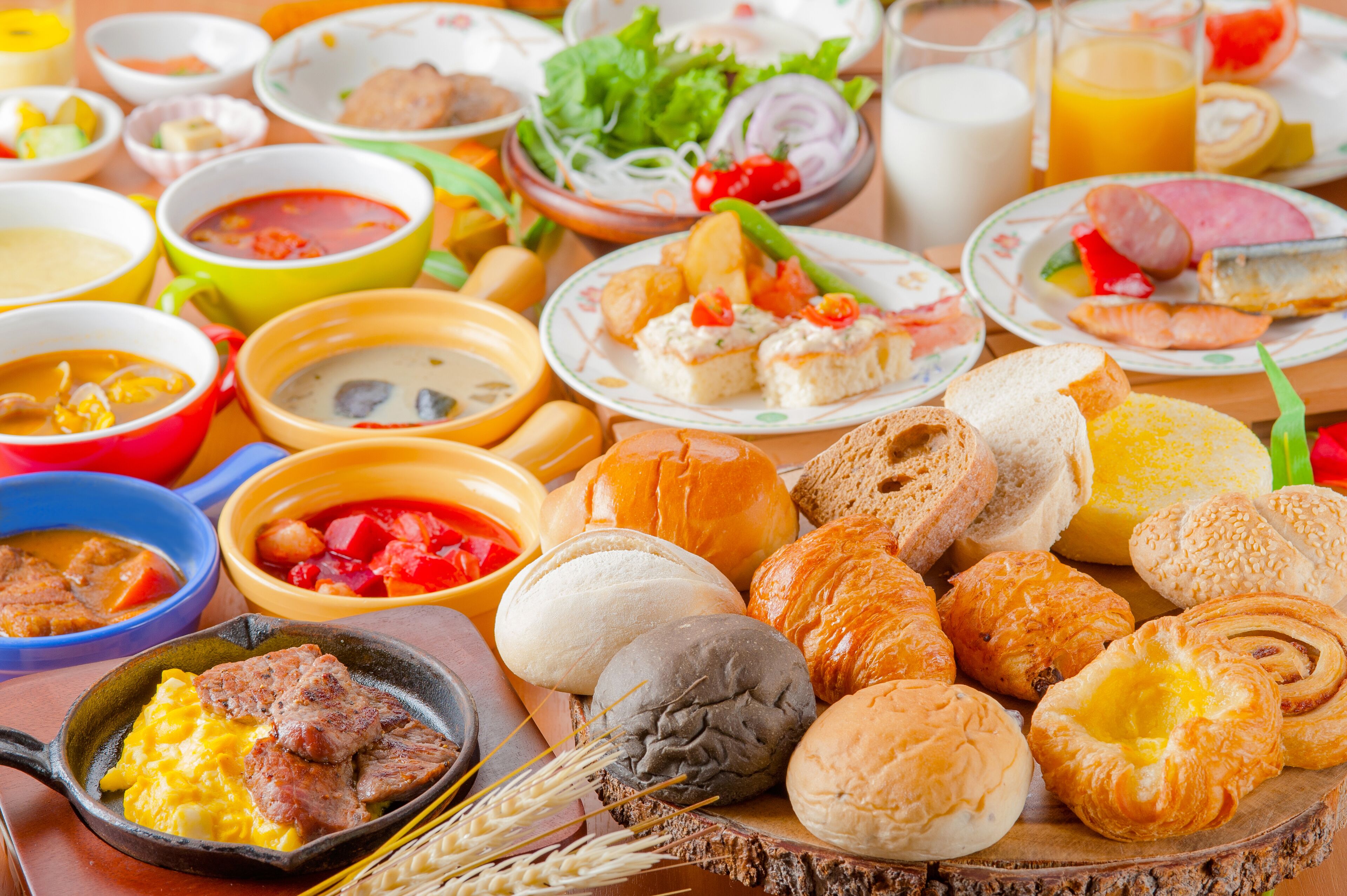 A variety of dishes including bread, pastries, and soup.