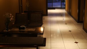 A hallway with a reception desk, seating area, and a vase of flowers. - Konpira-spa Yumoto Yachiyo (Kotohira)