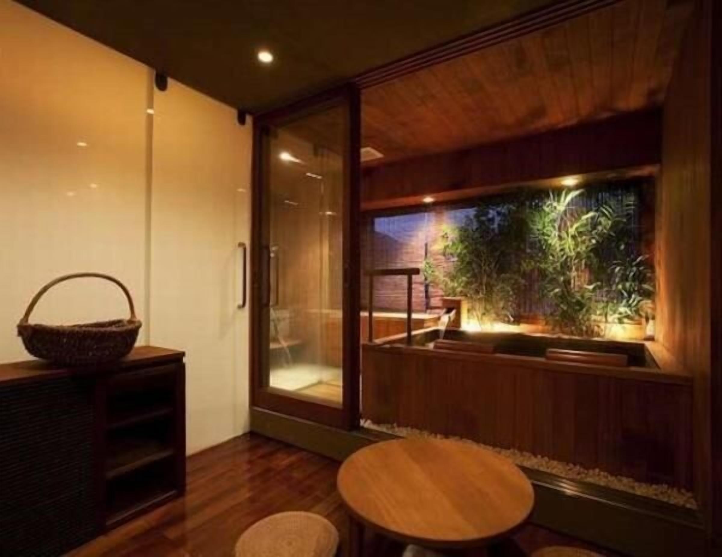 A modern interior with a sliding glass door leading to a balcony with a small water feature and plants.