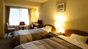 A hotel room with two beds, a desk with a computer, a chair, and a window with curtains. - Private spa Hotel Kotone (Kotohira)
