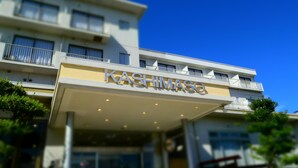 A hotel named "KASHIMASO" with a modern facade, balconies, and a clear blue sky in the background. - Beachside Hotel Kashimaso (Tonosho)