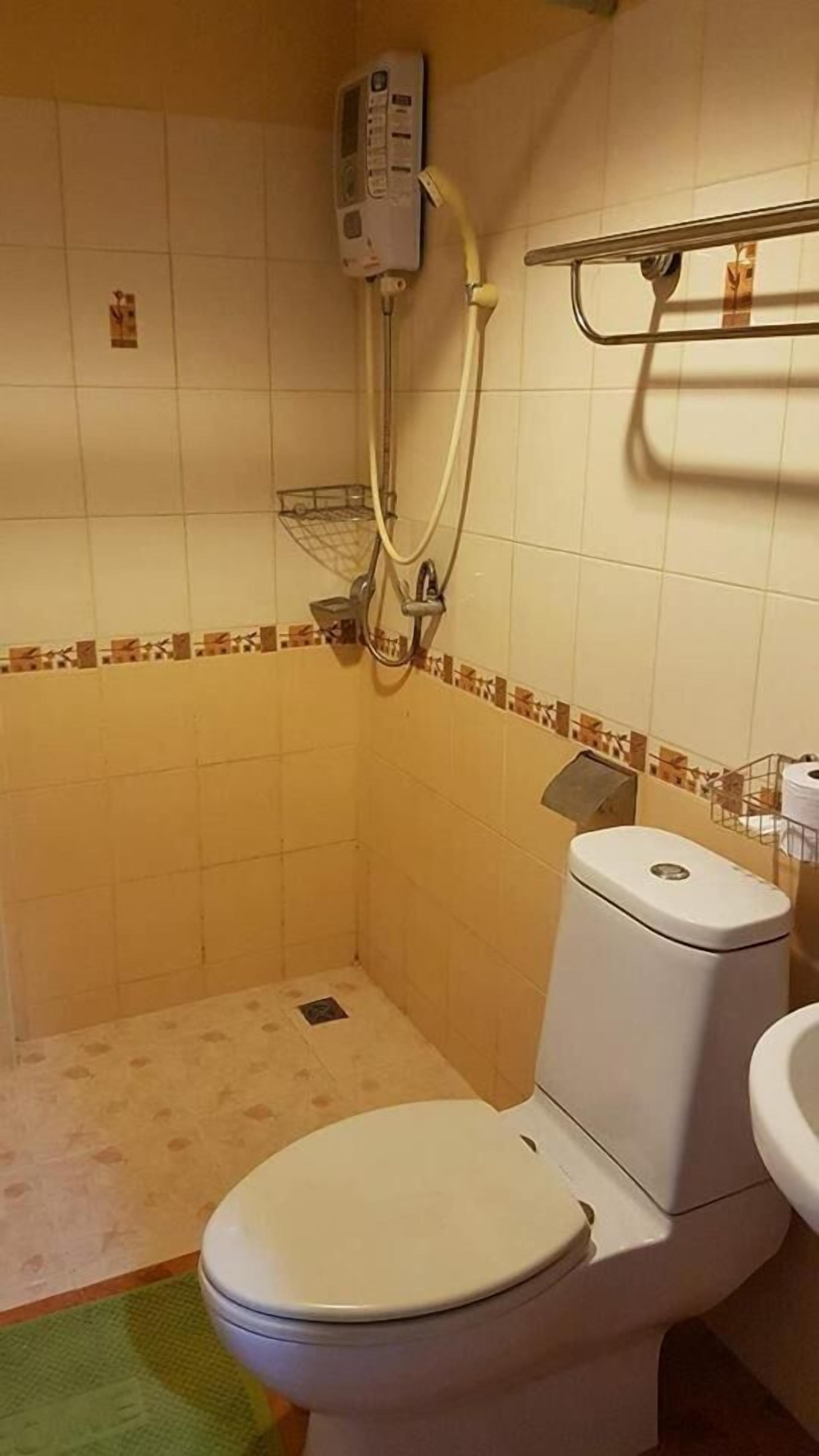 Une petite salle de bain avec des toilettes, une douche et un lavabo.