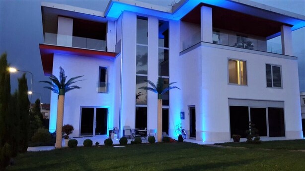 A modern two-story building with a flat roof and large windows. - Notte Stellata (Savigliano)