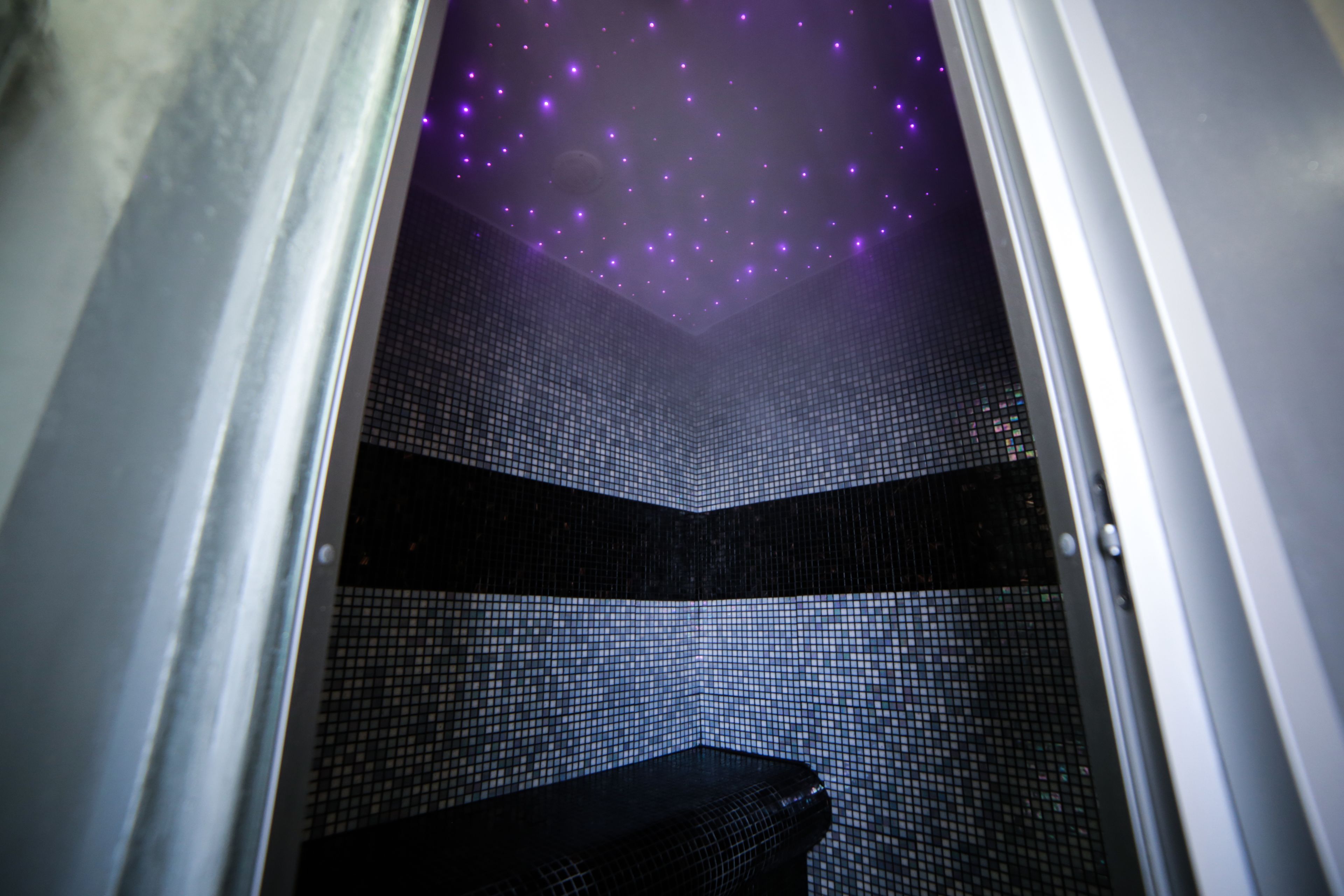 A bathroom with a tiled floor and a ceiling with a starry design.